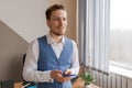 Young happy business man with beard smiling while reading his smartphone. Royalty Free Stock Photo