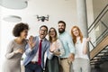 Young happy business people letting the drone camera to fly over the office and having fun