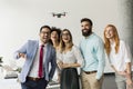Young happy business people letting the drone camera to fly over the office and having fun