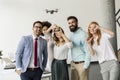 Young happy business people letting the drone camera to fly over the office and having fun