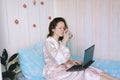 Young happy business woman lies in bed in pajamas in a cozy home. Online working, studying from home with laptop. Freelancer Royalty Free Stock Photo