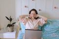 Young happy business woman lies in bed in pajamas in a cozy home. Online working, studying from home with laptop. Freelancer Royalty Free Stock Photo