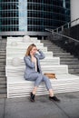 Young happy business woman talking on the phone in the background of an office building Royalty Free Stock Photo