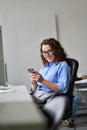 Young happy business woman using phone working in office at desk. Vertical Royalty Free Stock Photo