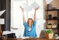 Young happy business woman working on computer and throws up papers in office