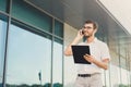 Young happy businessman making a call and holding clipboard Royalty Free Stock Photo