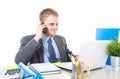 Young happy businessman smiling confident talking on mobile phone at office computer desk Royalty Free Stock Photo