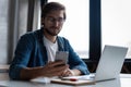 Young happy businessman smiling while reading his smartphone. Man working at his desk at home office Royalty Free Stock Photo