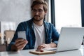 Young happy businessman smiling while reading his smartphone. Man working at his desk at home office Royalty Free Stock Photo