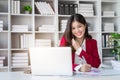 Young happy businesswoman talking on cellphone make notes and using laptop computer working online in modern office. Royalty Free Stock Photo