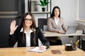 Young happy businesswoman using notebook in modern office with colleagues. A girl in a business suit looking at the camera and Royalty Free Stock Photo