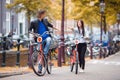 Young happy caucasian couple on bikes in old streets in Amsterdam Royalty Free Stock Photo