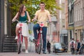 Young happy caucasian couple on bikes in old streets in Amsterdam Royalty Free Stock Photo