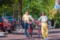 Young happy caucasian couple on bikes in old streets in Amsterdam Royalty Free Stock Photo