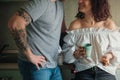 Young curly caucasian woman smiling to her man with tattoes and drinking tea Royalty Free Stock Photo