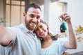 Young happy caucasian couple taking a selfie and holding the keys to their new house together. Young man taking a photo Royalty Free Stock Photo