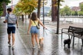 A young happy caucasian couple walking their dogs in a cloudy day in Spain in Bilbao