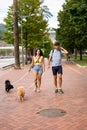 A young happy caucasian couple walking their dogs in a cloudy day in Spain in Bilbao and staring at the camera