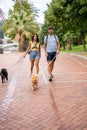 A young happy caucasian couple walking their dogs in a cloudy day in Spain in Bilbao and staring at the camera