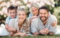 Young happy caucasian family relaxing and lying on grass together in a park. Loving parents spending time with their son Royalty Free Stock Photo