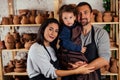 Young happy caucasian family with son working on potter shop .beautiful mother with dad and little boy making ceramic Royalty Free Stock Photo