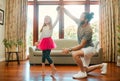 Young happy caucasian father and daughter dancing together in the lounge at home. Cheerful little girl practicing a Royalty Free Stock Photo