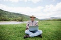 Young happy caucasian man freelancer working on his laptop outdoors in the mountains Royalty Free Stock Photo