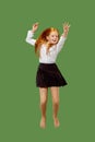 Young happy caucasian teen girl jumping in the air , isolated on green background Royalty Free Stock Photo