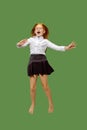 Young happy caucasian teen girl jumping in the air , isolated on green background Royalty Free Stock Photo