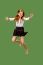 Young happy caucasian teen girl jumping in the air , isolated on green background Royalty Free Stock Photo