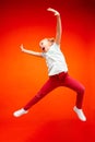 Young happy caucasian teen girl jumping in the air, on red studio background. Royalty Free Stock Photo