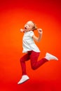 Young happy caucasian teen girl jumping in the air, isolated on red studio background. Royalty Free Stock Photo