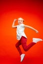 Young happy caucasian teen girl jumping in the air, on red studio background. Royalty Free Stock Photo