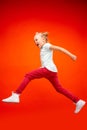 Young happy caucasian teen girl jumping in the air, on red studio background. Royalty Free Stock Photo