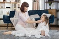 Young happy Caucasian woman mother, wiping with napkin face of her cute little 3 years old daughter, wrapped in a white Royalty Free Stock Photo