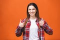 Young happy cheerful woman showing thumbs up isolated against orange background Royalty Free Stock Photo