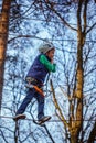 Young happy child boy in adventure park in safety equipment. Royalty Free Stock Photo