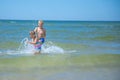 Girl and boy of having fun in water on beach and splashing Royalty Free Stock Photo