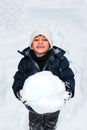 Young happy child playing with a big snow ball Royalty Free Stock Photo