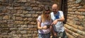 Young happy couple of alternative woman wearing sunglasses and bald man looking laughing and amazed pointing on the mobile phone a Royalty Free Stock Photo