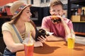 Young happy couple with burgers in cafe Royalty Free Stock Photo