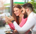 Young happy couple in cafe having fun, chatting and taking selfies together Royalty Free Stock Photo