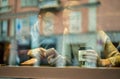 Young happy couple in coffee bar drinking cappuccino and having fun with cell phone - Cheerful people enjoying time together with Royalty Free Stock Photo