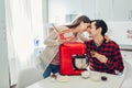 Young happy couple cooking on kitchen with food processor. Woman and man reading recipe and hugging Royalty Free Stock Photo