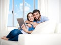 Young happy couple on couch at home enjoying using digital tablet Royalty Free Stock Photo