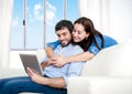 Young happy couple on couch at home enjoying using digital tablet Royalty Free Stock Photo