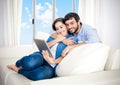 Young happy couple on couch at home enjoying using digital tablet Royalty Free Stock Photo