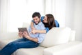 Young happy couple on couch at home enjoying using digital tablet computer Royalty Free Stock Photo