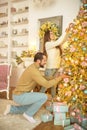 Young happy couple decorating christmas tree together Royalty Free Stock Photo