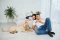 Young happy couple with dog sitting on sofa Royalty Free Stock Photo